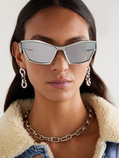 Matthew M. Williams makes his mark at Givenchy with styles like these sleek, futuristic sunglasses. 3D printed in Italy, they have angular cat-eye frames with sharp temples that almost create a wrap-around effect. Though free from obvious branding, the silver-tone metal that curves around the lenses subtly resembles a 'G'. Chic Silver Cat Eye Sunglasses With Gradient Lenses, Elegant Silver Cat Eye Sunglasses, Modern Silver Cat Eye Sunglasses With Gradient Lenses, Luxury Silver Cat Eye Sunglasses, Givenchy Sunglasses Women, Futuristic Sunglasses, Eyewear Womens, Cat Eye Frames, Cat Eye