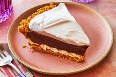 a piece of cake with white frosting on a pink plate next to a fork