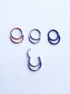 three pairs of metal rings sitting on top of a white table next to each other