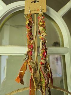 two pieces of fabric hanging from a rope on top of a window sill in front of a door