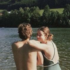 two people are standing in the water and one is holding his arm around the other