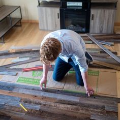 a young boy is working on wood flooring