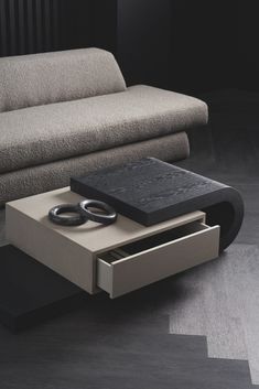 a modern coffee table with two rings on the top and one drawer open in front