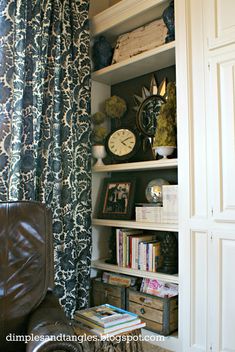 a living room with bookshelves and a clock on top of the bookcase