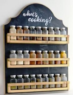 a wall mounted spice rack with chalkboard saying what's cooking?