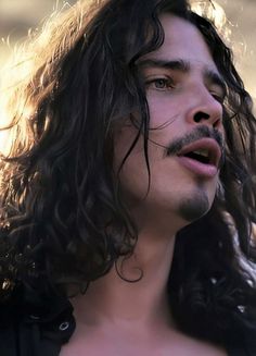 a close up of a person with long hair and no shirt in front of the camera