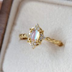 an opal and diamond ring in a box