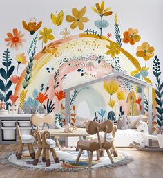 a room with flowers painted on the wall and chairs in front of it, including two children's playrooms