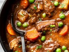 a bowl filled with meat and vegetables on top of a table