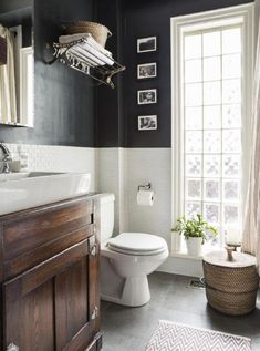 a white toilet sitting next to a window in a bathroom