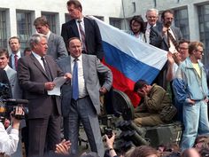 a group of people standing next to each other in front of a building with a flag on it