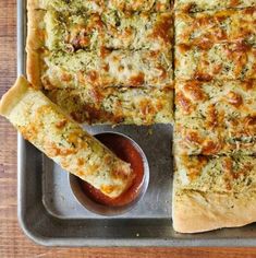 the pizza is cut and ready to be served on the table with dipping sauces