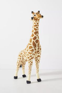 a stuffed giraffe standing on top of a white floor