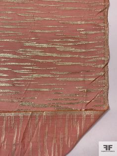 an old pink and gold cloth with metallic stripes on the edges, folded in two rows