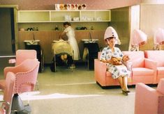 a woman sitting on a pink couch in a room