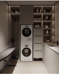 a washer and dryer in a small room with shelves on the wall behind them