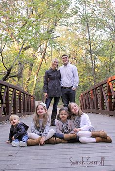 a family poses for a photo on a bridge