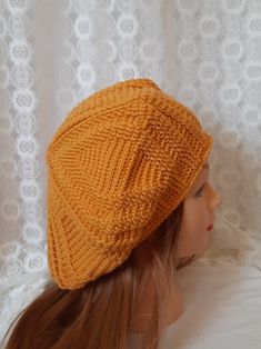 an orange knitted hat sitting on top of a mannequin's head