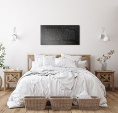 a bed with white sheets and purple flowers on the headboard, next to two wicker baskets