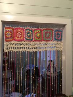 the window is decorated with colorful beads and crocheted trimmings on it