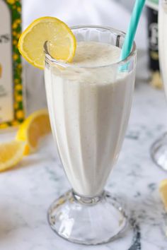 two glasses filled with milk and lemons on a table