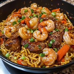 a bowl filled with noodles, meat and veggies on top of a table