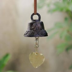 a bell with a heart hanging from it