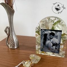 a couple's photo is placed on a table next to a vase