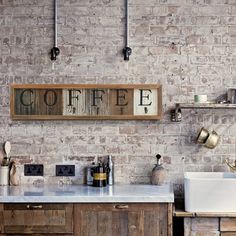 a brick wall in a kitchen with two sinks and an old fashioned faucet