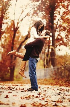 a man holding a woman in the air while she holds her on top of him