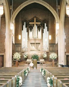 an image of a church with flowers on the alter and candles in the pews