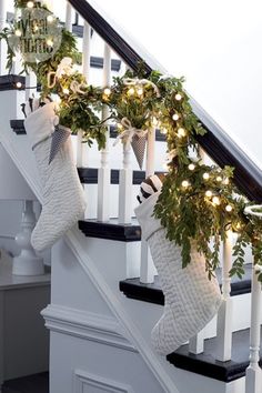 stockings hung on the banisters decorated with christmas lights and greenery, along with garland