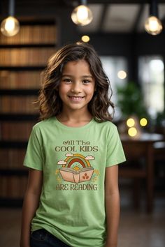 Kids Reader T-Shirt The kids heavy cotton tee is perfect for everyday use.  The fabric is 100% cotton for solid colors. Polyester is included for heather-color variants.  These fabrics are prime materials for printing.  The shoulders have twill tape for improved durability. The collar is curl resistant due to ribbed knitting.  There are no seams along the sides.  .: Material: 100% cotton (fiber content may vary for different colors) .: Midweight fabric (5.3 oz/yd² (180 g/m .: Classic fit .: Tear-away label .: Runs true to size SIZING: Runs true to size, but please refer to size chart, to order according to your exact measurements. Sweatshirt https://moonlitwonderland.etsy.com/listing/1614431226 Sweatshirt https://moonlitwonderland.etsy.com/listing/1582559870 Sweatshirt https://moonlitwonde Kids Reading, Kids Tops, The Cool, Twill Tape, Color Choices, Cotton Fiber, Cool Kids, Color Matching, Different Styles