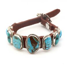 Admire the breathtaking grandeur of Danny Martinez's incredible Navajo bracelet. Seven shimmering turquoise stones, including a central one measuring 5/8" x 7/8", come together to create a mesmerizing fashion piece. This brown leather bracelet is fastened with a resplendent sterling silver buckle, adjustable to fit wrists up to 9" in circumference. The image shows the exact item that you will receive. Navajo Jewelry Leather, Navajo Bracelet, Brown Leather Bracelet, Turquoise Leather, Turquoise Stone, Brown Leather, Leather Bracelet, Buckle, Turquoise