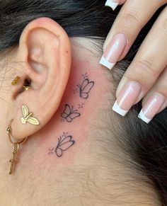 a close up of a person's ear with butterflies on it