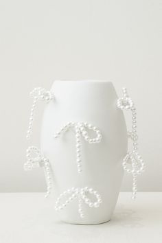 a white vase that has beads on it