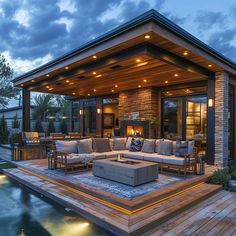 an outdoor living area with couches and tables next to a swimming pool at dusk