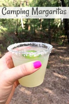 a person holding up a drink in front of the camera with text reading camping margaritas