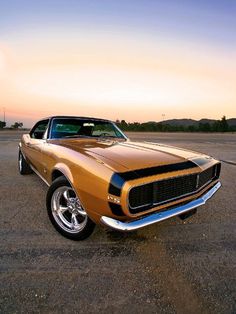 an orange muscle car parked in a parking lot