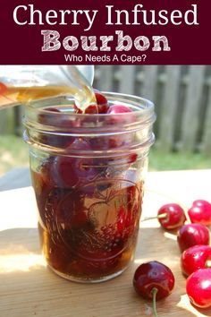 cherry infused bourbon is being poured into a mason jar with cherries on the side