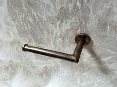 a metal handle on a white marble wall