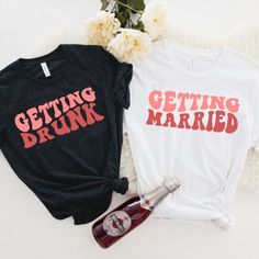 two t - shirts that say getting drunk and getting married next to a bottle of wine