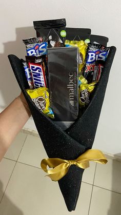 a person holding up a black bag filled with candy