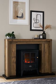 a wood burning fireplace in a living room with pictures on the wall and rugs