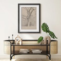 a living room with a table, plant and pictures on the wall