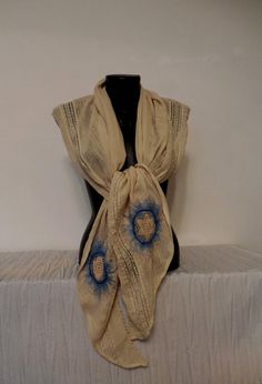 a white and blue scarf sitting on top of a bed