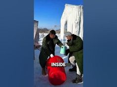 two men standing next to each other near a red barrel with the word inside on it