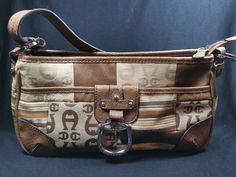 This is an original vintage Aigner shoulder bag purse. It is made of brown genuine leather and a patchwork of different cloth fabrics. It measures 12 inches in length, 6 inches in height and 3 1/2 inches in depth.  It has a side pocket with a silver chrome metal pull opening. It is lined inside with cotton fabric and has 3 separate compartments, one that is zippered. Inside the zippered compartment, there are an additional 5 side pockets. The top handle measures 10 inches from the top of the bag. This purse is in very good condition inside and out. Handmade Vintage Brown Shoulder Bag, Vintage Brown Shoulder Bag With Zipper Pocket, Vintage Distressed Brown Shoulder Bag With Leather Lining, Vintage Brown Shoulder Bag With Zipper Closure, Brown Shoulder Bag With Silver-tone Hardware, Star Knife, Vintage Horse, Brown Leather, Purses And Handbags