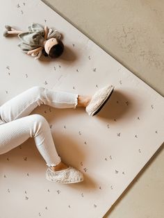 a doll laying on top of a mat next to a stuffed animal