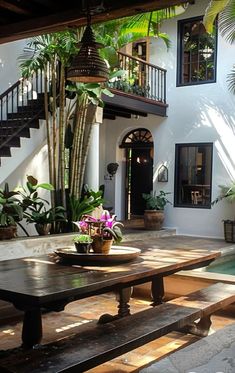 a wooden table sitting in the middle of a patio next to a pool and stairs